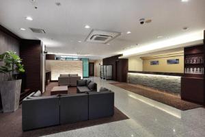 a lobby with a couch and chairs in a building at Via Inn Shin Osaka in Osaka