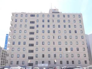 a large building with cars parked in front of it at Via Inn Shin Osaka in Osaka