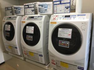 four washing machines are lined up on a shelf at Via Inn Shin Osaka in Osaka