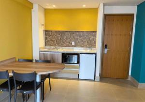 eine Küche mit Tisch und Stühlen und einem Kühlschrank in der Unterkunft Solar das Águas Park Resort in Olímpia