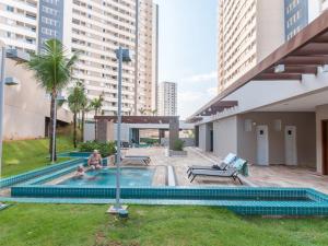 Ein Mann, der in einem Schwimmbad in einem Gebäude sitzt. in der Unterkunft Solar das Águas Park Resort in Olímpia
