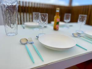 una mesa con un plato blanco, tenedor y cuchara en Le "61" MARINA ROOFTOP 2CH 2SDB TERRASSE MARINA, en Baimbridge