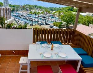 a table on a balcony with a view of a marina at Le "61" MARINA ROOFTOP 2CH 2SDB TERRASSE MARINA in Baimbridge