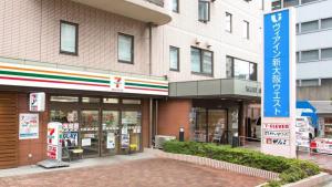 Via Inn Shin Osaka West في أوساكا: محل على شارع امام مبنى