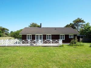 a house with a white fence in front of it at 6 person holiday home in Rødby-By Traum in Rødby