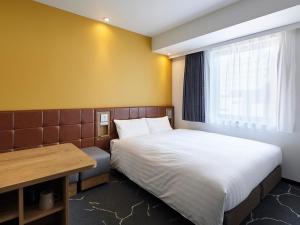 大阪市にあるヴィアイン心斎橋（ＪＲ西日本グループ）のベッドとデスクが備わる小さな客室です。