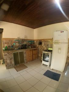 a kitchen with a refrigerator and a stove at Habitat Marajó Hostel in Soure