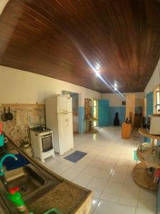a kitchen with a refrigerator and a counter top at Habitat Marajó Hostel in Soure