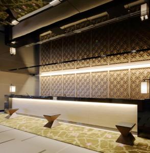 a lobby with a counter and a wall with tiles at Via Inn Abeno Tennoji in Osaka
