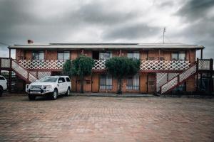 a white truck parked in front of a brick building at Diamond House Heritage Restaurant and Motor Inn in Stawell