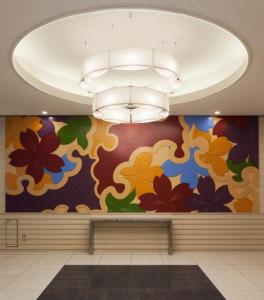 a lobby with a colorful mural on the wall at Via Inn Kanazawa in Kanazawa