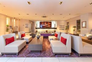 a lobby with white furniture and red pillows at Via Inn Kanazawa in Kanazawa
