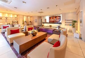 a living room with white chairs and a table at Via Inn Kanazawa in Kanazawa