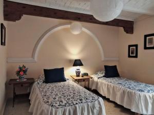 two beds in a room with an arched ceiling at Villa Sueño Azul B&B in Guanajuato