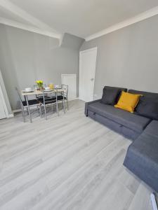 a living room with a couch and a table at Contractor's favourite. Home away from home feel in West Thurrock