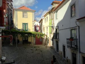 uma pessoa andando por um beco em uma cidade em Casa d'Alfama by Lisbon Village Apartments em Lisboa