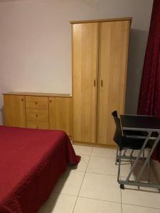 a bedroom with a bed and a desk and a cabinet at Valletta Private Room in Valletta