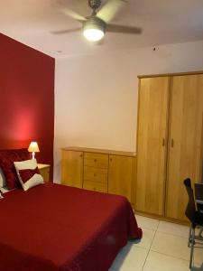 a bedroom with a red bed and wooden cabinets at Valletta Private Room in Valletta