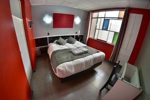a bedroom with a bed in a red room at Wifala Thematic Hotel Boutique in Cusco