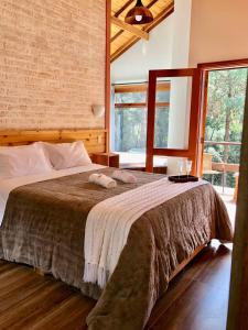 una camera con un grande letto con un muro di mattoni di Afha 48 a Monte Verde
