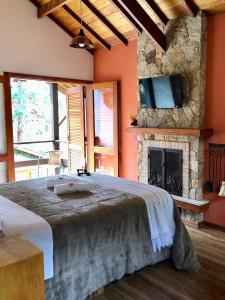 um quarto com uma cama grande e uma lareira em Afha 48 em Monte Verde