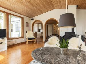Holiday home Svendborg XIII في سفينبورغ: غرفة معيشة بسقف خشبي وطاولة
