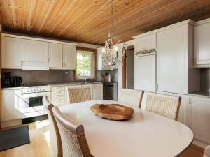 uma cozinha com uma mesa branca e um tecto de madeira em Holiday home Svendborg XIII em Svendborg