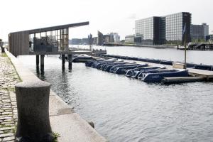 a row of boats parked at a dock in the water at Hotel Copenhagen Apartments in Copenhagen