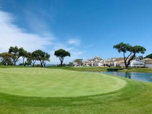 a green golf course with a pond and houses at Spectacular Penthouse apartment in magnificent San Roque Club in San Roque