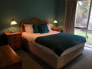 um quarto com uma cama grande e uma janela em Countryside Retreat romantic tranquil native wildlife township Hepburn - Daylesford em Hepburn Springs
