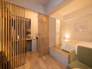 a room with a bed, a dresser and a window at Roppongi Hotel S in Tokyo