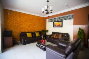 a living room with two leather couches and a tv at Hotel Tinkus Inn in Lima