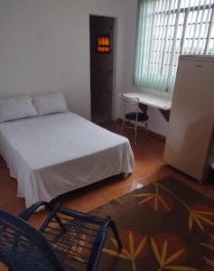 1 dormitorio con 1 cama, 1 silla y 1 mesa en Pousada Recanto Alaketu Hospedagens, en Campo Grande