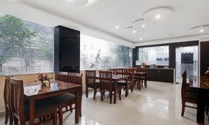 海得拉巴Treebo Kruthika Residency的有桌椅和窗户的餐厅
