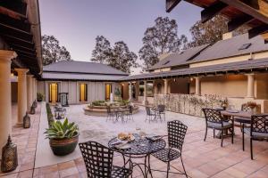 an outdoor patio with tables and chairs at Tower Lodge in Pokolbin