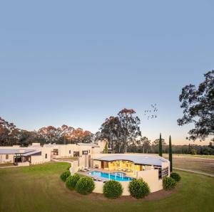 an exterior view of a house with a swimming pool at Tower Lodge in Pokolbin