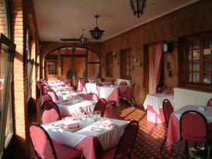eine Reihe von Tischen in einem Restaurant mit roten Stühlen in der Unterkunft Hotel Alisa in Lerma