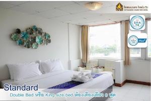 1 dormitorio con 1 cama con reloj en la pared en Navanakorn Golden View, en Ban Lam Rua Taek