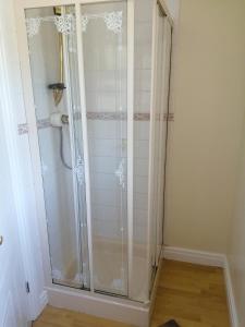 um chuveiro com uma porta de vidro na casa de banho em The Old School em Donington on Bain