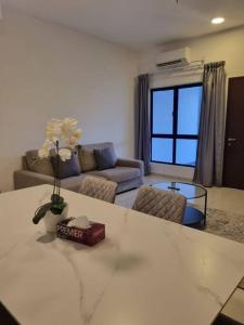 Modern 4BR Double Storey @ Setia Alam في شاه عالم: غرفة معيشة مع أريكة وطاولة مع زهور