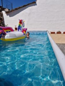 a young boy in a swimming pool with an inflatable at Casa Adelin in Eşelniţa