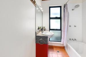 y baño con lavabo y bañera. en COASTING - Straddie Style Beach House en Point Lookout