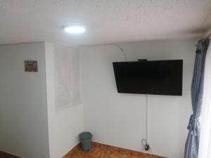 a flat screen tv on a white wall in a room at Habitación Privada Cerca al Aeropuerto y Terminal in Bogotá