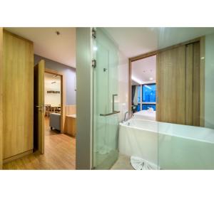 a bathroom with a shower and a bath tub at PLAAI Prime Hotel Rayong SHA Extra Plus in Rayong