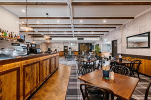 un restaurante con mesas y sillas de madera y un bar en Boomerang Hotel, en Mackay