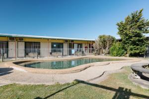 een gebouw met een zwembad voor een gebouw bij Boomerang Hotel in Mackay