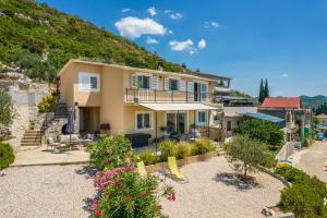 a house with a hill in the background at Apartman ELLA in Peračko Blato