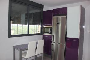 eine Küche mit Tisch und Kühlschrank in der Unterkunft Sierra de Chiva Villa in Chiva