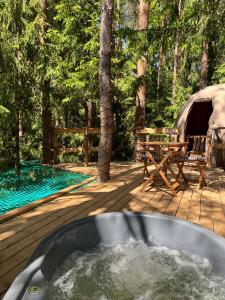 Būtingė的住宿－Nature calls - tree tents，帐篷旁甲板上的热水浴池