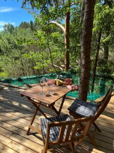 einen Holztisch und zwei Stühle auf einer Terrasse in der Unterkunft Nature calls - tree tents in Būtingė
